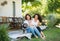 Woman with daughter and baby granddaughter resting outdoors in backyard.