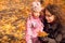 Woman with daughter and collect maple leaves