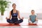 Woman and daughter meditating together. Fitness lifestyle