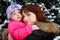 Woman with daughter stands near tree