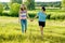 Woman with daughter teen walking in nature holding hands.