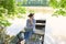 Woman daydreaming with laptop in boat on lake