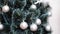 Woman decorate artificial Christmas tree with balls and bows