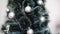Woman decorate artificial Christmas tree with balls and bows