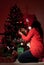 Woman decorate Christmas tree in night