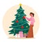 A woman decorates a Christmas tree