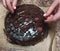 Woman decorating chocolate cake a berries