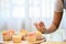 Woman decorating cupcake, making cupcake in her free time in kitchen