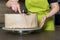 Woman decorating a delicious layered sponge cake with chocolate icing cream