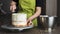 Woman decorating a delicious layered sponge cake with icing cream