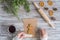 Woman decorating honey gingerbread men on wooden grey table and craft paper. Christmas Icing bakery. Flat lay.