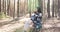 Woman deep breathing resting, sitting in chair with tourist backpack in pine forest in sun shin