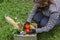 Woman delivering donations box with food during Covid 19 outbreak.Feme volunteer collects food in a box standing on the grass