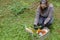 Woman delivering donations box with food during Covid 19 outbreak.Feme volunteer collects food in a box standing on the grass