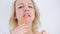 woman demonstrates a new orange toothbrush She removes cap of special device for cleaning teeth and shows how to brush