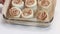 A woman demonstrates sliced cinnamon dough for baking cinnabons. In a baking dish. Close-up shot