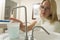 Woman in dental exam room reaching for water