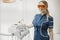 Woman dentist in blue uniform standing next to dental equipment in stomatology.