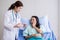 Woman dentist talking with her female patient explain with tooth model and preparing to treatment at dentalcenter