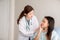 Woman dentist talking with her female patient explain with toothache model and preparing to treatment at dental center