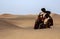 Woman in a desert with a water dish