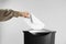 Woman destroying envelope with shredder on grey background, closeup