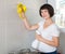 Woman with detergent cleaning tiled wall