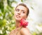 Woman with diamond earrings, ring and flower