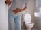 Woman with diarrhea standing in the bathroom, holding her stomach. Severe stomach pain, prepare to sit dung in the bathroom