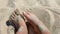 Woman digging with feet in the sand. Person playing burying his feet in dry sand