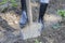 Woman digging in the garden with black boots