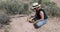 Woman digging for valuable minerals and rocks desert 4K