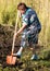 A woman digs a garden with a shovel