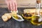 Woman dipping fresh bread into tasty olive oil with spices in bowl. Olive oil bread dip.