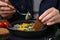 Woman dipping piece of bread into egg yolk, closeup. Eating tasty Shakshuka