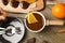 Woman dipping slice of  into fondue pot with milk chocolate at wooden table, top view