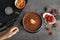 Woman dipping tangerine into pot with chocolate fondue