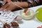 A woman dips strawberries in white melted chocolate. Cooking strawberries glazed in chocolate