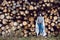 woman director is standing by a log at a sawmill in a scarf and a blue hat