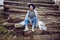 woman director is standing by a log at a sawmill in a scarf and a blue hat