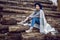 woman director is standing by a log at a sawmill in a scarf and a blue hat