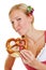 Woman in dirndl chews a pretzel