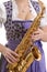 Woman in dirndl dress playing saxophone, detail