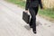 Woman on the dirt road with briefcase