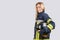 woman with dirty face in uniform of firefighter holds hardhat in hand