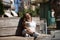 Woman with disability, reduced mobility and small stature sitting on a wooden bench, happy and relaxed sunbathing. Concept