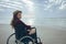 Woman disable sitting on wheelchair at beach