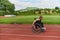 A woman with disablity driving a wheelchair on a track while preparing for the Paralympic Games