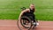 A woman with disablity driving a wheelchair on a track while preparing for the Paralympic Games