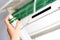 Woman disinfecting the indoor unit of air conditioner